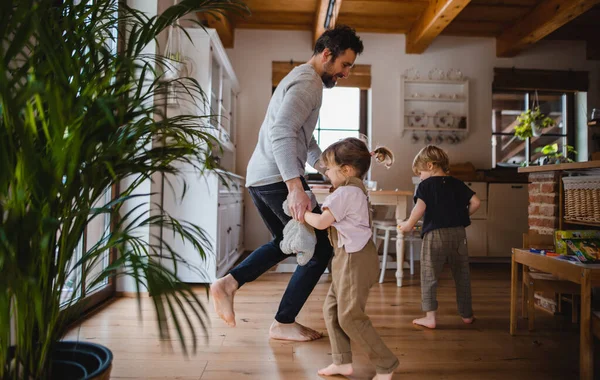 Ayah dewasa dengan dua anak kecil menari di dalam ruangan di rumah. — Stok Foto