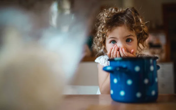 Niña feliz sentada en la mesa dentro de casa, comiendo espaguetis y mirando la cámara. — Foto de Stock