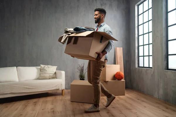 Feliz joven sosteniendo cajas de embalaje moviéndose a casa, nuevo concepto de vida. — Foto de Stock