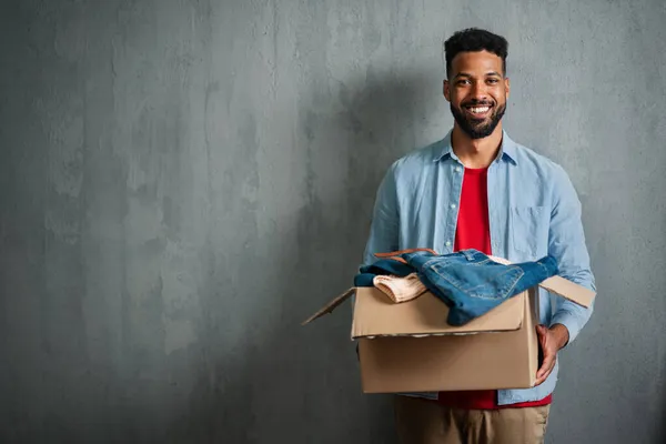 Happy young man holding packing boxes moving home, looking at camera, new living concept. — Stock Photo, Image