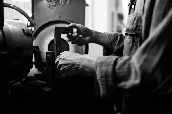 Black and white close up of man hand with caliper measure steel component indoors in metal workshop. — Stock Photo, Image