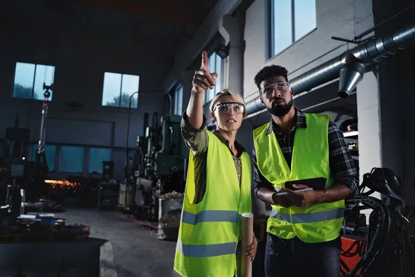 Retrato de inspectores industriales haciendo un chequeo general en interiores en taller de metal. — Foto de Stock