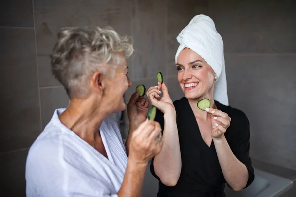 Feliz madre mayor en albornoz con hija adulta en el interior de casa, concepto de autocuidado. — Foto de Stock