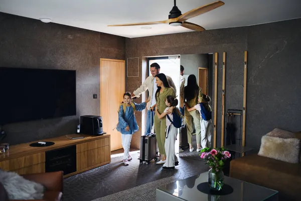 Happy young family with two children enetring room at luxury hotel, summer holiday. — Stock Photo, Image