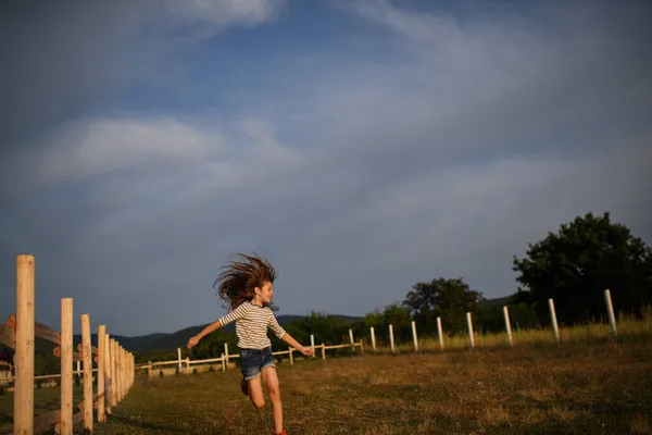 Felice bambina divertirsi e correre all'aperto in fattoria — Foto Stock