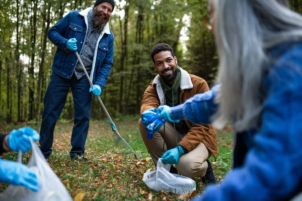 Vielfältige Gruppe glücklicher Ehrenamtlicher, die Wald von Abfall befreien, Konzept der gemeinnützigen Arbeit. — Stockfoto