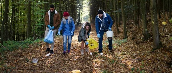Διαφορετική ομάδα ευτυχισμένων εθελοντών που καθαρίζουν τα δάση από τα απόβλητα, έννοια της κοινωνικής υπηρεσίας. — Φωτογραφία Αρχείου