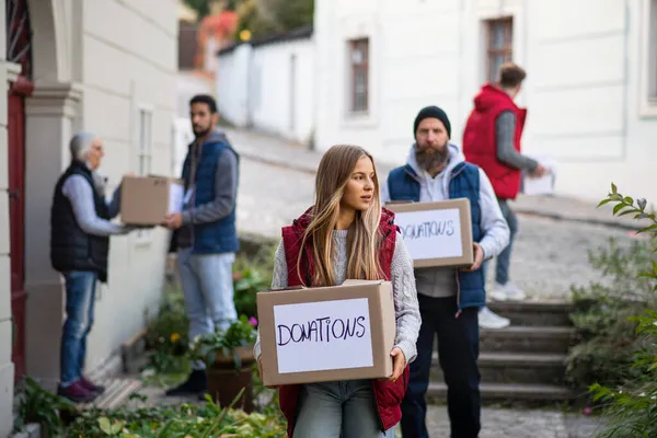 Різноманітна група волонтерів з подарунковими коробками, що стоять на відкритому повітрі, соціальної допомоги та благодійної концепції — стокове фото