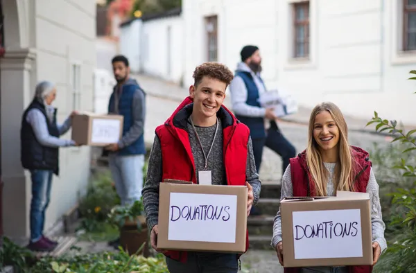 Diversi gruppi di volontari con scatole di donazione in piedi all'aperto, assistenza sociale e concetto di carità — Foto Stock