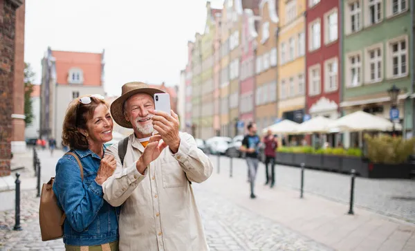 Retrato de la feliz pareja de turistas mayores haciendo selfie al aire libre en la ciudad histórica — Foto de Stock