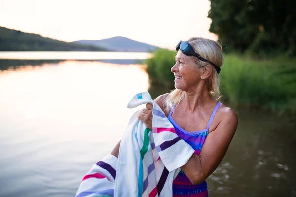 Πορτρέτο της δραστήριας ηλικιωμένης γυναίκας κολυμβήτρια στεγνώνει με towell σε εξωτερικούς χώρους δίπλα στη λίμνη. — Φωτογραφία Αρχείου