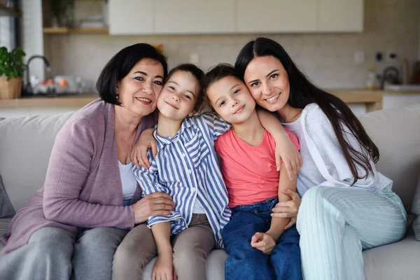 Boldog kislányok anyával és nagymamával otthon, a kamerába nézve. — Stock Fotó