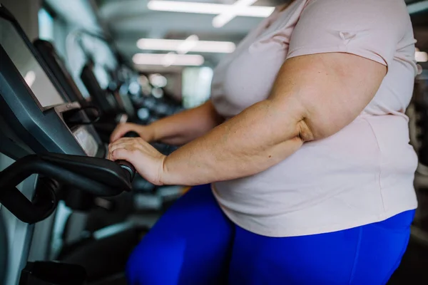 Sezione centrale della donna in sovrappeso che esercita sul tapis roulant al chiuso in palestra — Foto Stock