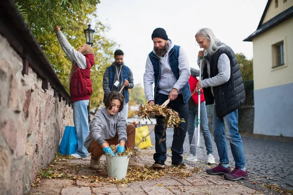 Vidám önkéntesek sokszínű csoportja takarítja fel az utcát, közmunka koncepció — Stock Fotó