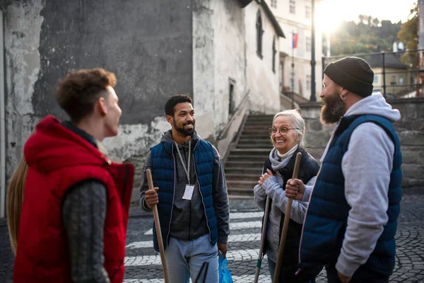 Grupo de voluntários felizes conversando e prontos para limpar rua, conceito de serviço comunitário — Fotografia de Stock