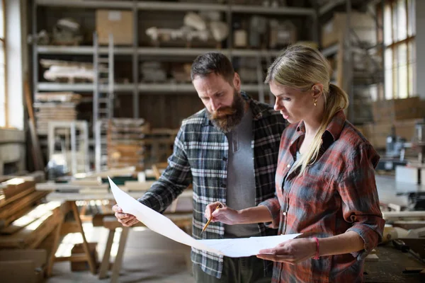 Dos carpinteros hombre y mujer hablando de diseño de productos. Concepto de pequeña empresa. — Foto de Stock