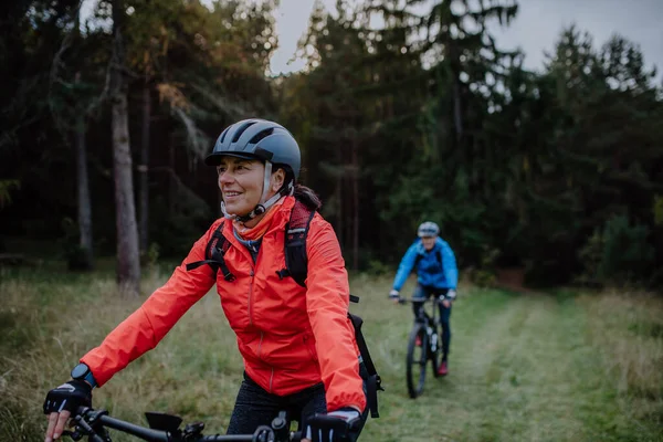 활동적 인 시니어 부부 가가을에 숲 속에서 자전거를 타고 노는 모습. — 스톡 사진