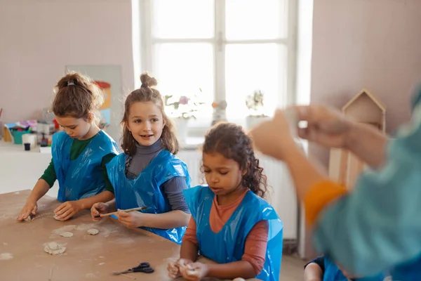 Gruppo di bambini che lavorano con argilla ceramica durante la classe di arte creativa e artigianato a scuola. — Foto Stock