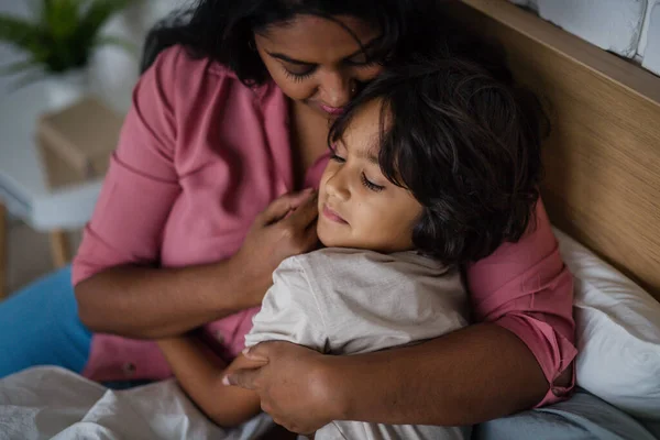 Крупный план индийской матери, обнимающей своего маленького сына дома. — стоковое фото
