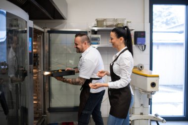 Mutlu aşçı ve aşçı lokantanın mutfağında bulaşıkları yıkıyor..