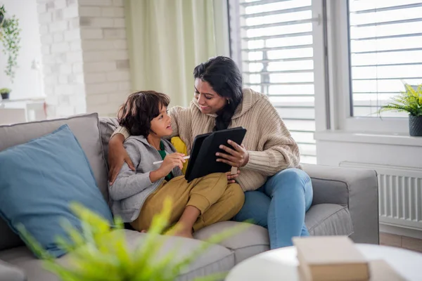 Indiase moeder met behulp van tablet met haar kleine zoon en plezier hebben thuis. — Stockfoto