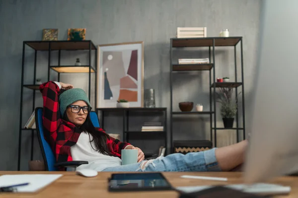 Éditeur vidéo féminin reposant les pieds à l'intérieur dans un studio de bureau créatif. — Photo