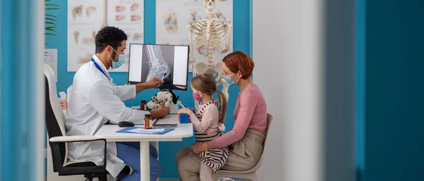 Little girl with her mother at doctors office on consultation, coronavirus concept. — Stock Photo, Image