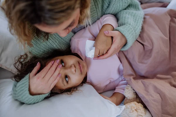 Mère prenant soin de sa fille malade à la maison. — Photo