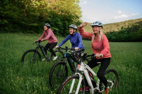 Happy aktivní senioři přátelé cyklistika spolu venku v přírodě. — Stock fotografie