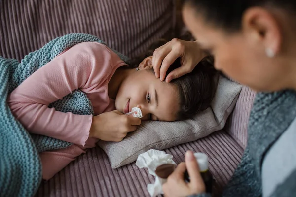 Mère prenant soin de sa fille malade à la maison . — Photo