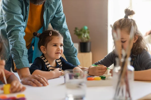 Groupe de petits enfants travaillant sur un projet avec le professeur lors de cours d'art créatif et d'artisanat à l'école. — Photo