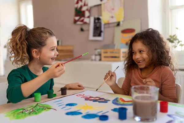 Szczęśliwe małe dziewczynki malowanie obrazu podczas zajęć artystycznych i rzemiosła w szkole. — Zdjęcie stockowe
