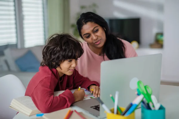 Indiase moeder met kleine zoon met behulp van laptop en het hebben van online school les thuis. — Stockfoto