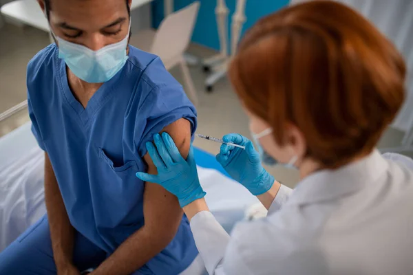 High angle view of of doctor getting covid-19 vaccince from his colleague. — Stock Photo, Image