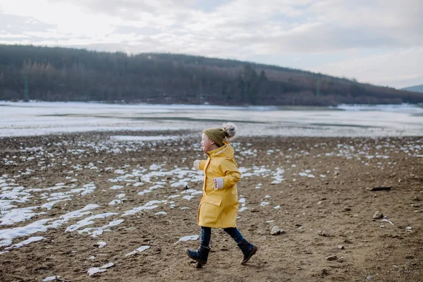 Gelukkige kleine jongen met Down loopt buiten door het meer in de winter. — Stockfoto