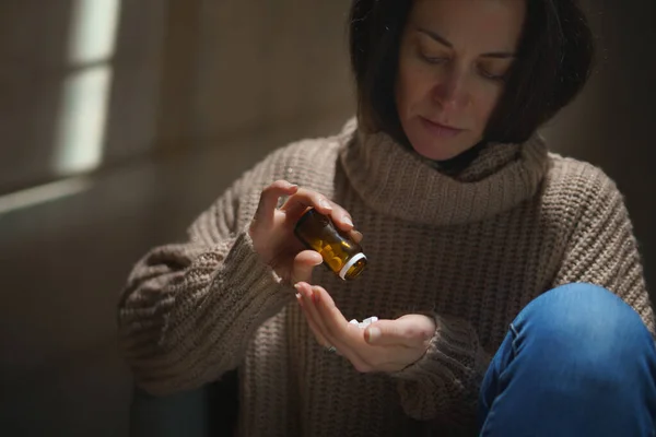 Mujer deprimida tomando pastillas, concepto de salud mental. — Foto de Stock