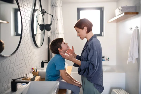 Mãe conversando com o pequeno filho no banheiro em casa. — Fotografia de Stock