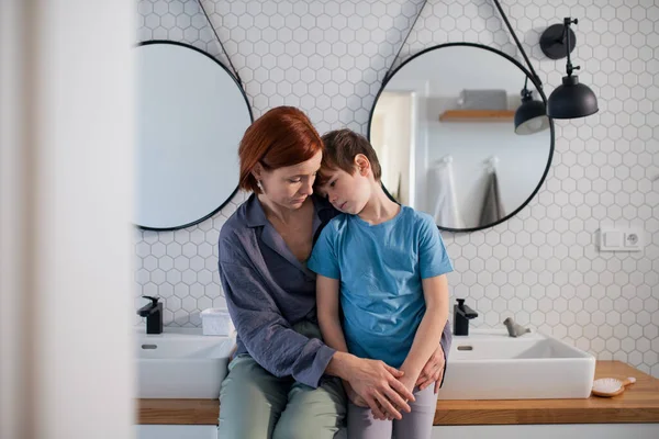 Μητέρα αγκαλιάζει και παρηγορεί μικρό αγόρι στο μπάνιο στο σπίτι. — Φωτογραφία Αρχείου