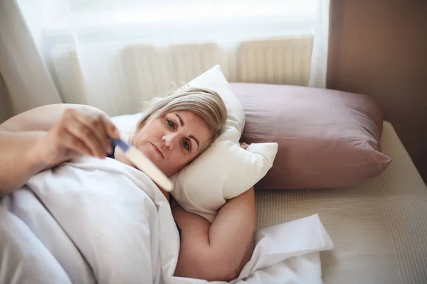 Enfermo mujer con sobrepeso acostado en la cama en casa. — Foto de Stock