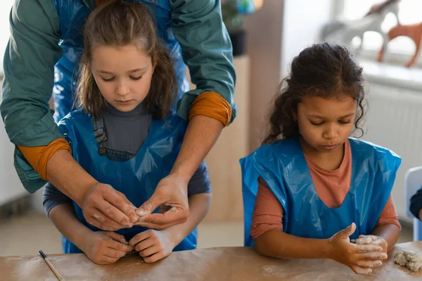 Little kids with teacher working with pottery clay during creative art and craft class at school. — Stock Photo, Image