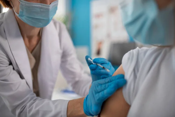 Primer plano del joven recibiendo la vacuna covid-19 de su médico en la clínica. — Foto de Stock