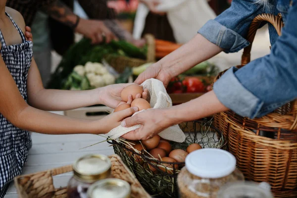 Zbliżenie z małą dziewczynką kupującą organiczne jaja na świeżym powietrzu na lokalnym rynku rolników. — Zdjęcie stockowe