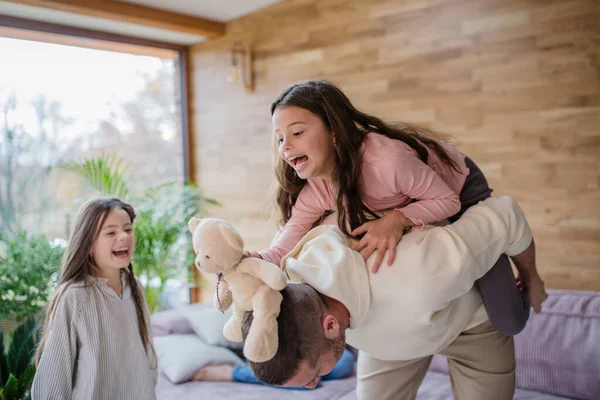 Két boldog nővér szórakozik apával otthon. — Stock Fotó