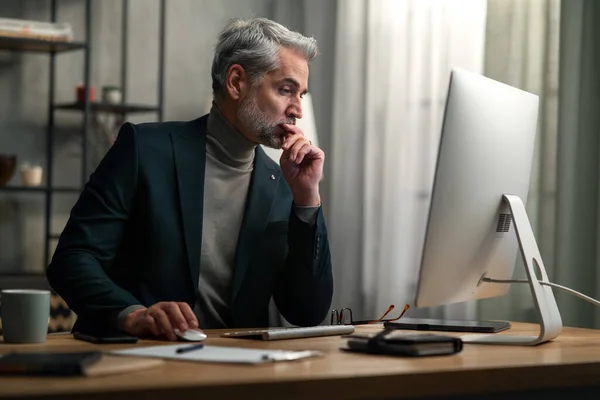 Volwassen zakenman werkt op de computer binnen in het kantoor. — Stockfoto