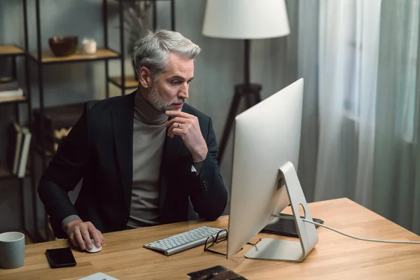 Volwassen zakenman werkt op de computer binnen in het kantoor. — Stockfoto