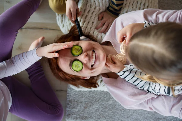 Küçük Chidlren annelerinin yüzüne salatalık sürüp ona evde makyaj yapıyor.. — Stok fotoğraf