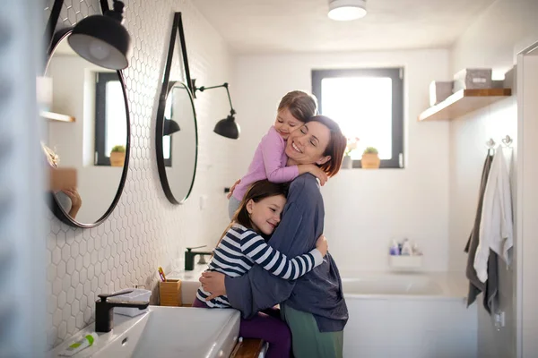 Mother hugging her little children in bathroom at home. — Stock Photo, Image