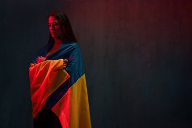 Ukrayna bayrağıyla kaplanmış üzgün bir kadın. Rusya ile savaşta Ukrayna ulusuyla birlikte olma kavramı.