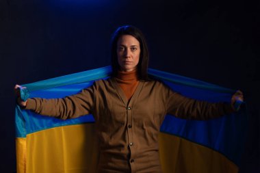 Ukrayna bayrağı taşıyan üzgün kadın. Rusya ile savaşta Ukrayna ulusuyla birlikte olma kavramı.