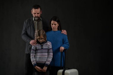 Siyah arka plana bakan bir çocuklu mülteci ailesi, Ukrayna savaş konsepti.